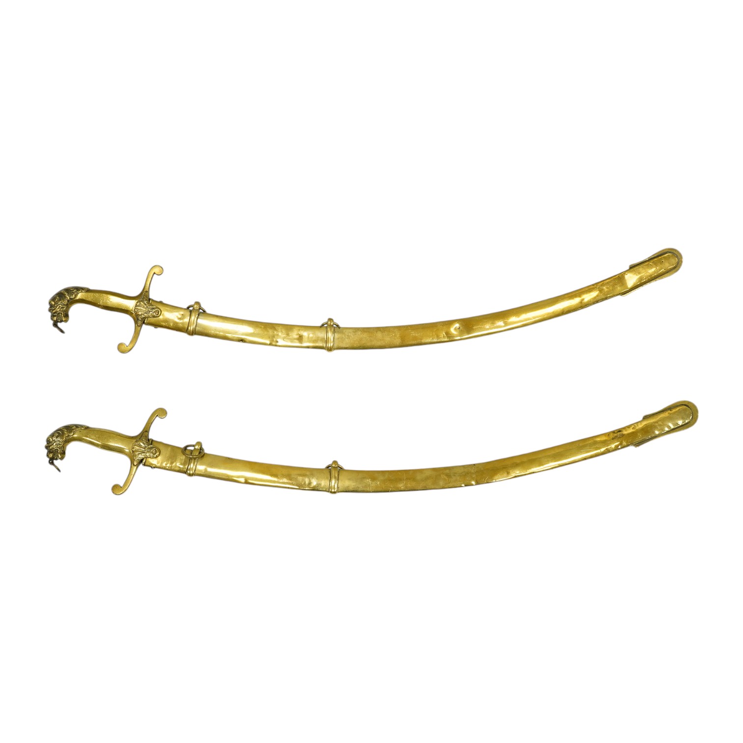 A pair of Victorian bandsman’s swords of Shamshir type, curved single edge blades, cast brass hilts with lions head pommels, in their brass scabbards. Condition - good, some dents to scabbards.